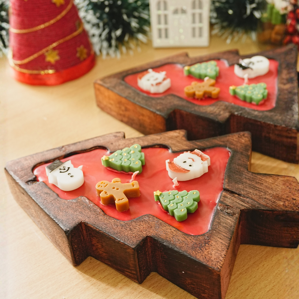 Wooden mold with Christmas-themed candy decorations on a wooden surface.